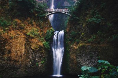 Low angle view of arch bridge over waterfall