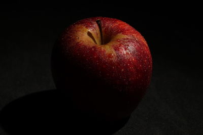 Close-up of apple on table against black background