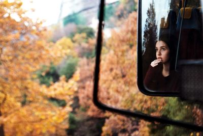 Reflection of woman in side-view mirror