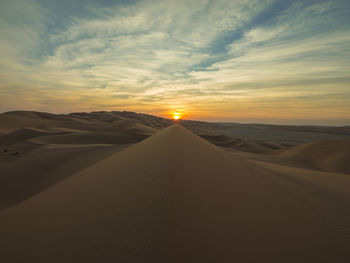 Scenic view of desert against sky during sunset