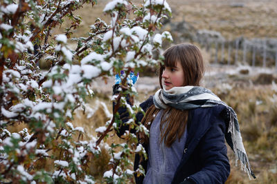 Full length of woman standing by tree during winter