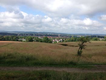 Rural landscape against cloudy sky
