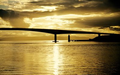 Bridge over river against sky during sunset