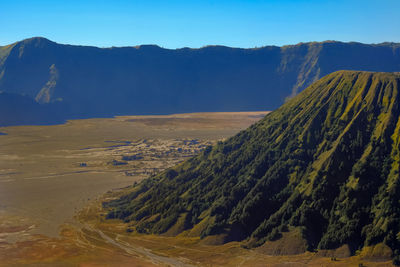 Scenic view of landscape and mountains against clear blue sky