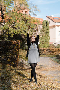 Full length of woman standing by tree