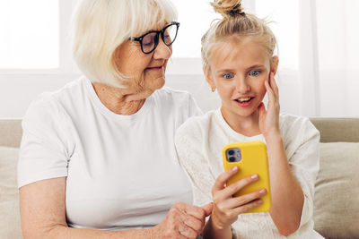 Young woman using mobile phone while sitting at home