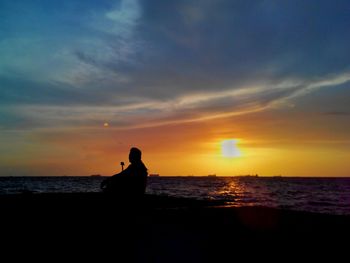 Silhouette of people on beach during sunset