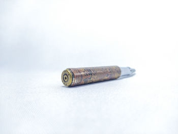 Close-up of cigarette on table against white background
