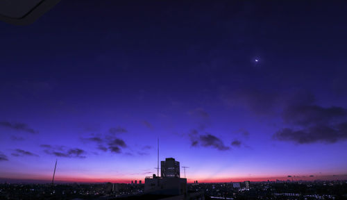 Illuminated buildings against sky at night