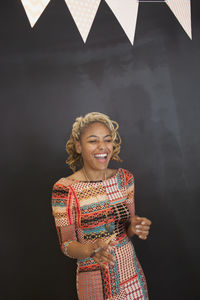 Smiling young woman standing against the background in a classroom