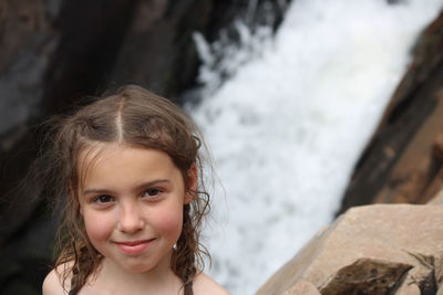 Portrait of smiling girl against waterfall