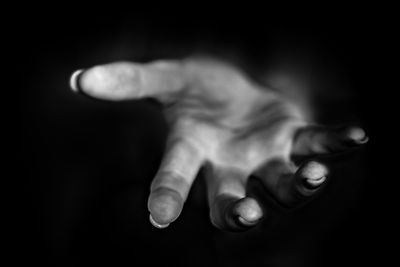 Close-up of human hand against black background