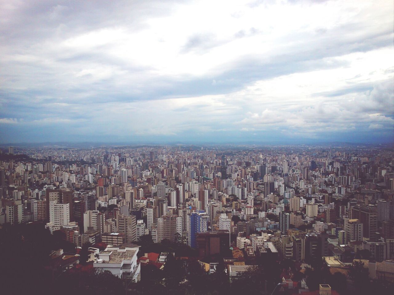 city, cityscape, building exterior, architecture, built structure, sky, crowded, cloud - sky, skyscraper, high angle view, cloudy, city life, cloud, modern, tower, tall - high, residential district, aerial view, office building, capital cities