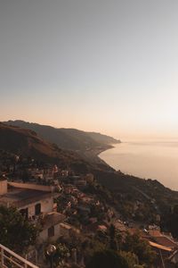 High angle view of townscape by sea against clear sky