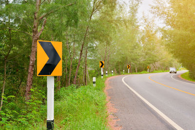 Road sign against trees