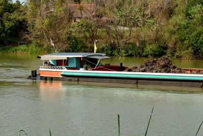 Boat sailing in lake against trees