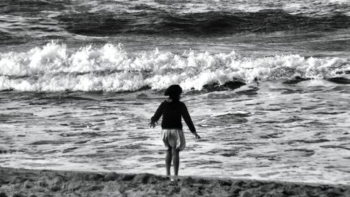 Rear view of man standing on beach