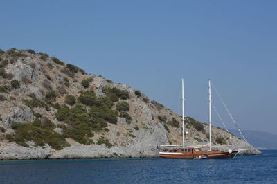 Sailboat sailing on sea against clear blue sky