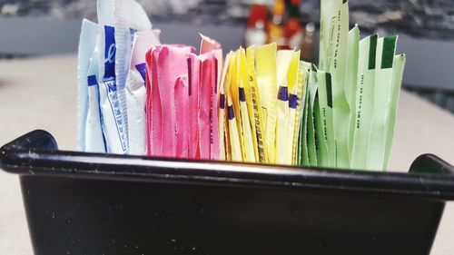 Close-up of multi colored sugar packets 