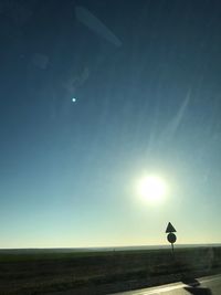 Scenic view of silhouette field against bright sun