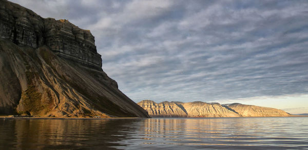 Rock formations by sea against sky