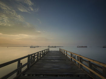 Pier over sea against sky during sunset