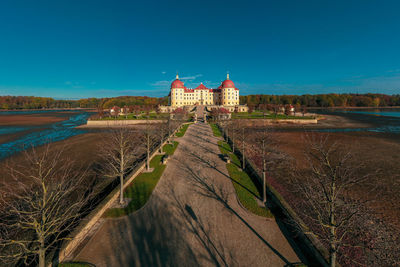 View of river by building against blue sky