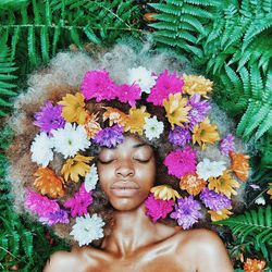 High angle view of woman lying on plants with flowers