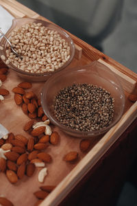 Pine nuts in a glass plate on a wooden table. organic healthy raw vegan food.