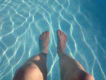 Low section of person standing in water