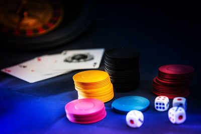 Close-up of gambling chips with dices and cards on table in casino