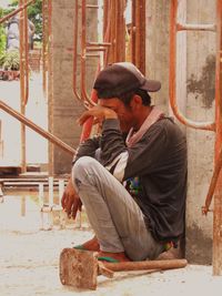 Crying manual worker sitting at construction site