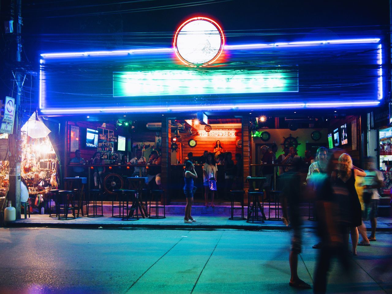 illuminated, men, architecture, building exterior, built structure, lifestyles, night, city, person, street, city life, large group of people, leisure activity, walking, medium group of people, city street, incidental people, full length, blurred motion