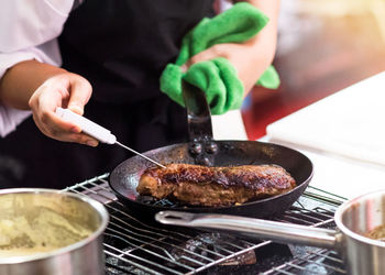 Midsection of man preparing food in kitchen