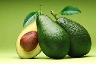 Close-up of avocados against green background