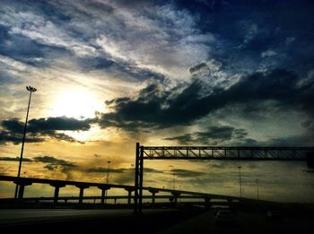 Bridge over sea against cloudy sky