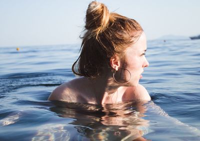 Portrait of woman at beach against sky