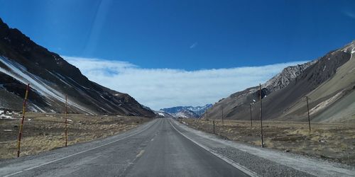 Road amidst snowcapped mountains against sky