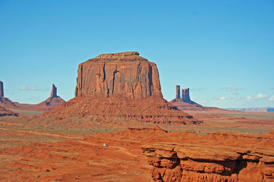 View of rock formations on landscape against blue sky