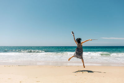 Full length of man at beach against clear sky