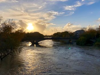 Scenic view of river against sky at sunset