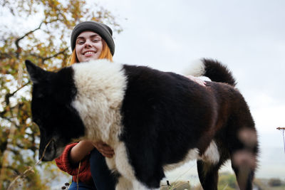 Full length of happy woman with snow in park during winter