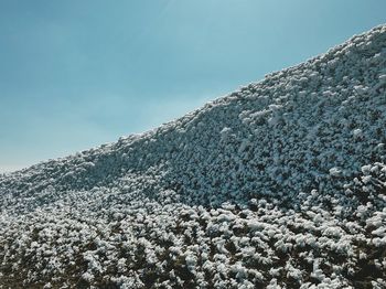 Low angle view of snow covered mountain against sky