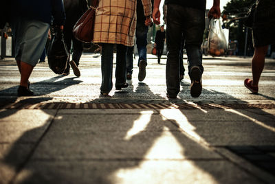 Low section of people walking on street