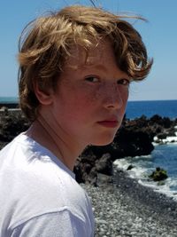 Portrait of teenage boy at beach during sunny day