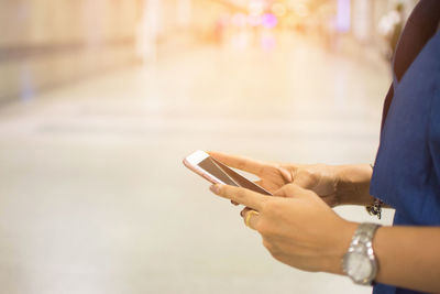 Midsection of woman using mobile phone