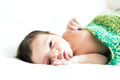 Portrait of cute baby lying on bed