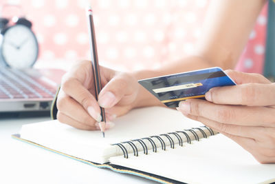 Close-up of woman using mobile phone on table