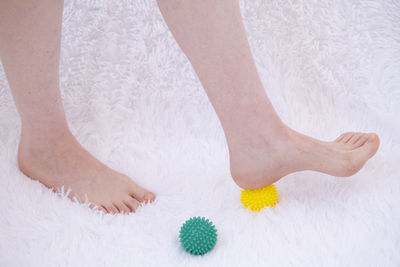 Low section of woman standing on bed