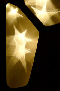 Close-up of illuminated lighting equipment against black background